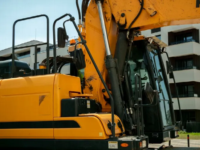 Close-up of a yellow excavator in an urban construction site in Wrocław, Poland.