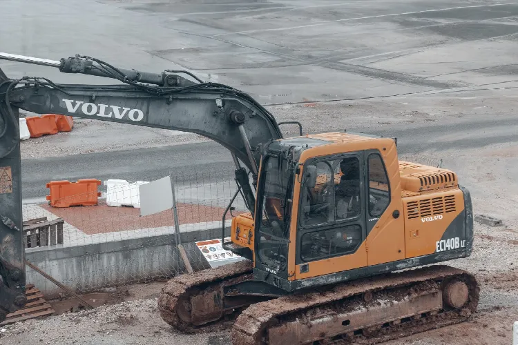 Żółta koparka Volvo na placu budowy - hydraulika w pracy
